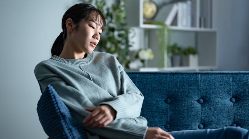 ソファで落ち込む女性